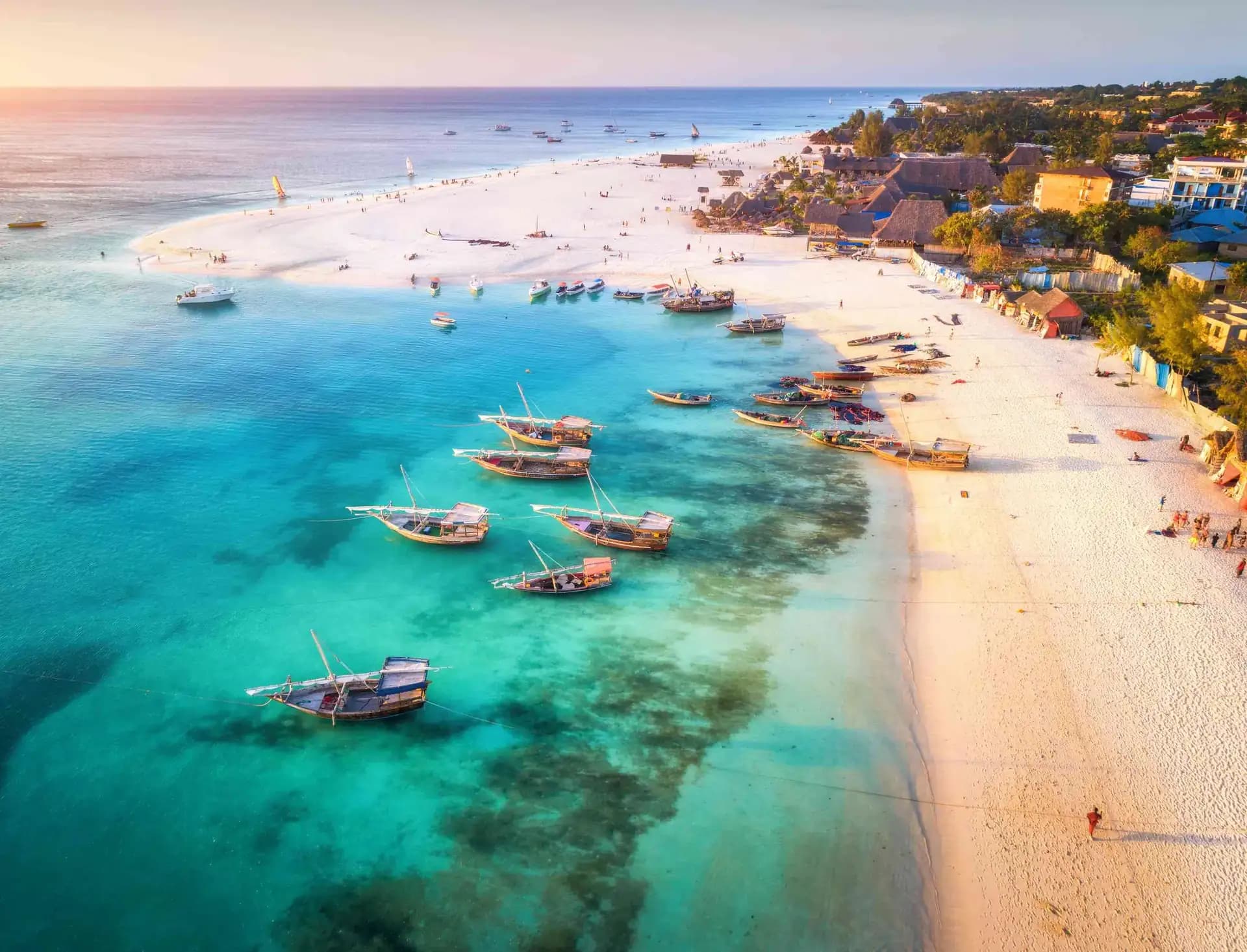 Traditional dhow boats on the turquoise shallows of a Zanzibar beach, Tanzania